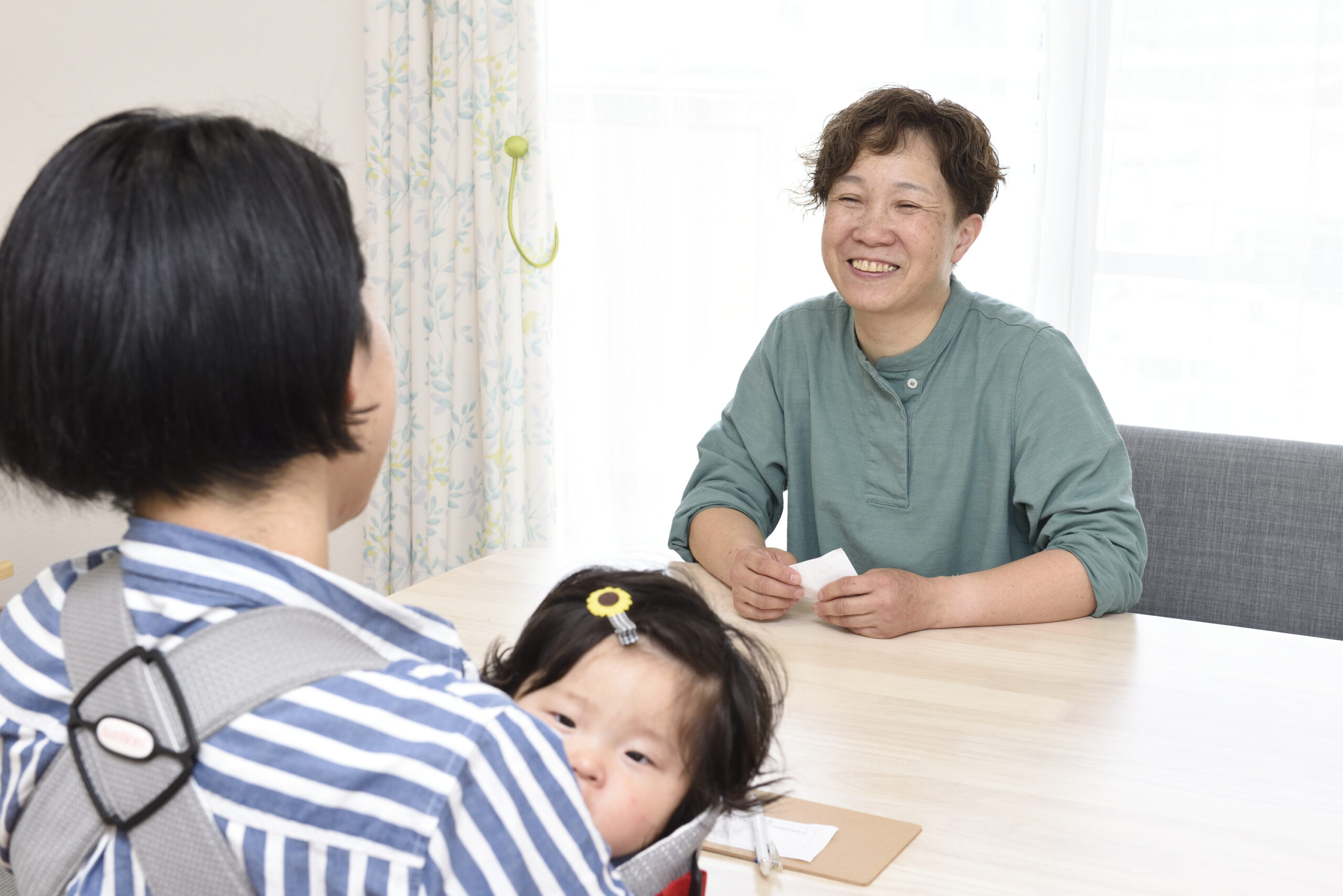 代表がお子様を抱えているお客様と話している写真